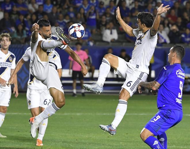 Giancarlo Gonzalez #21 de Los Angeles Galaxy y Servando Carrasco #6 alejan el balón de Milton Caraglio #9 de Cruz Azul en el partido que los enfrentó en el Dignity Health Sports Park en Carson, California.