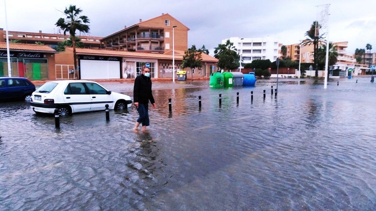 Un vecino camina por una avenida de la playa del Arenal totalmente anegada.