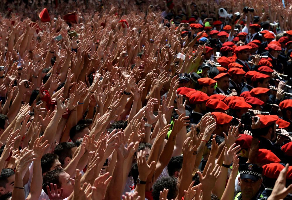 Gente levantando las manos en la plaza del Ayuntamiento mientras toca la banda municipal en el inicio de los Sanfermínes en Pamplona, España