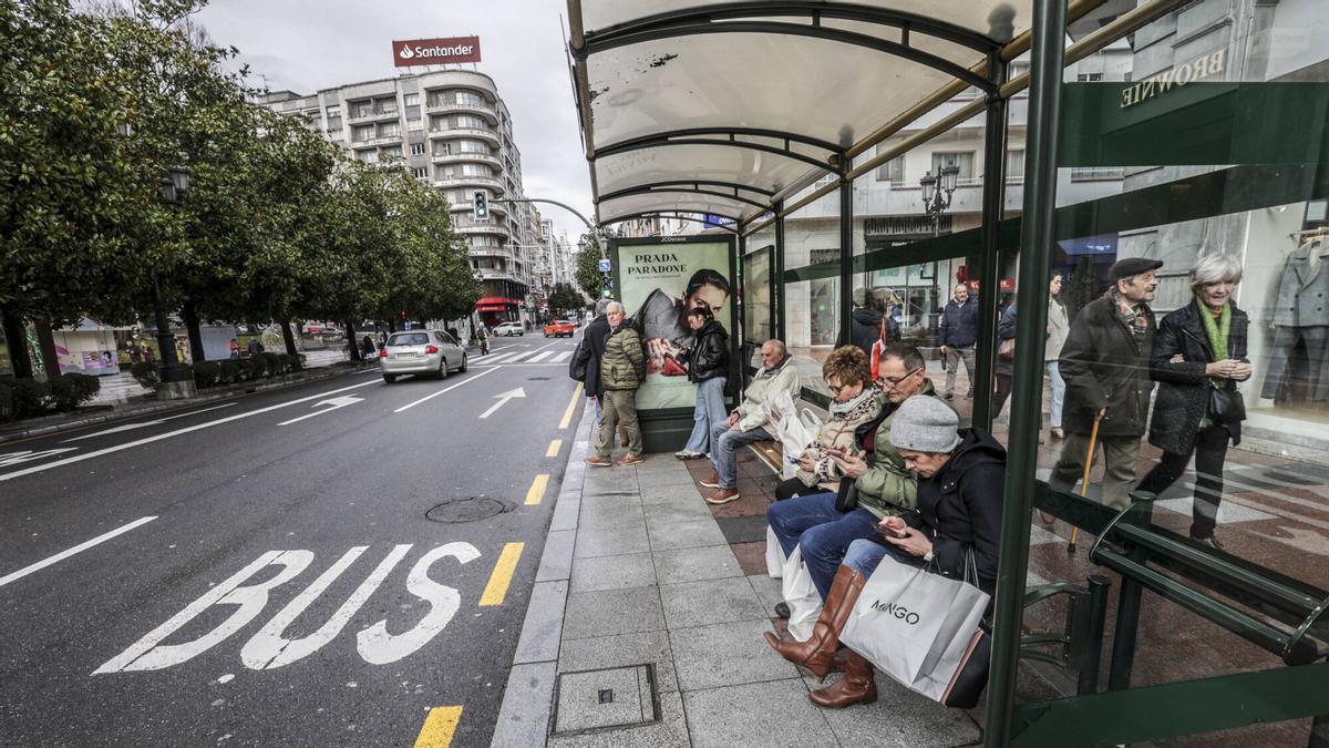 Usuario del bus urbano de Oviedo, en una parada en la calle Uría.