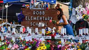 Una niña deposita flores en un memorial improvisado en la Escuela Primaria Robb en Uvalde, Texas, el 28 de mayo de 2022. (Foto de CHANDAN KHANNA / AFP)