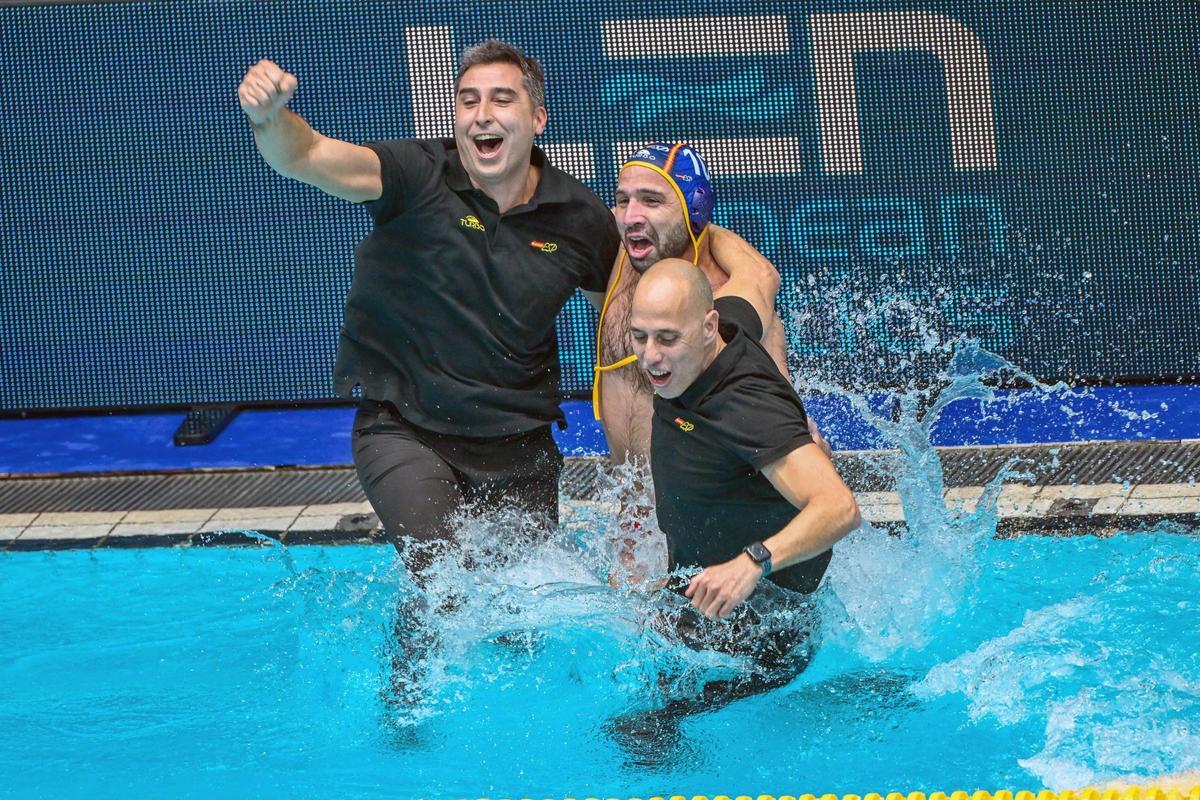 El entrenador principal de España David Martin Lozano  y el jugador Felipe Perrone Rocha saltan al agua después de ganar el partido final del Campeonato Europeo de Waterpolo Masculino