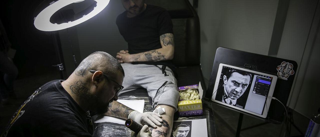 El tatuador Jose Bandera, con un cliente ’reincidente’ desde hace 10 años, en su estudio Soul Hunter Tatto &amp; Piercing de L’Hospitalet de Llobregrat, a principios de mayo.