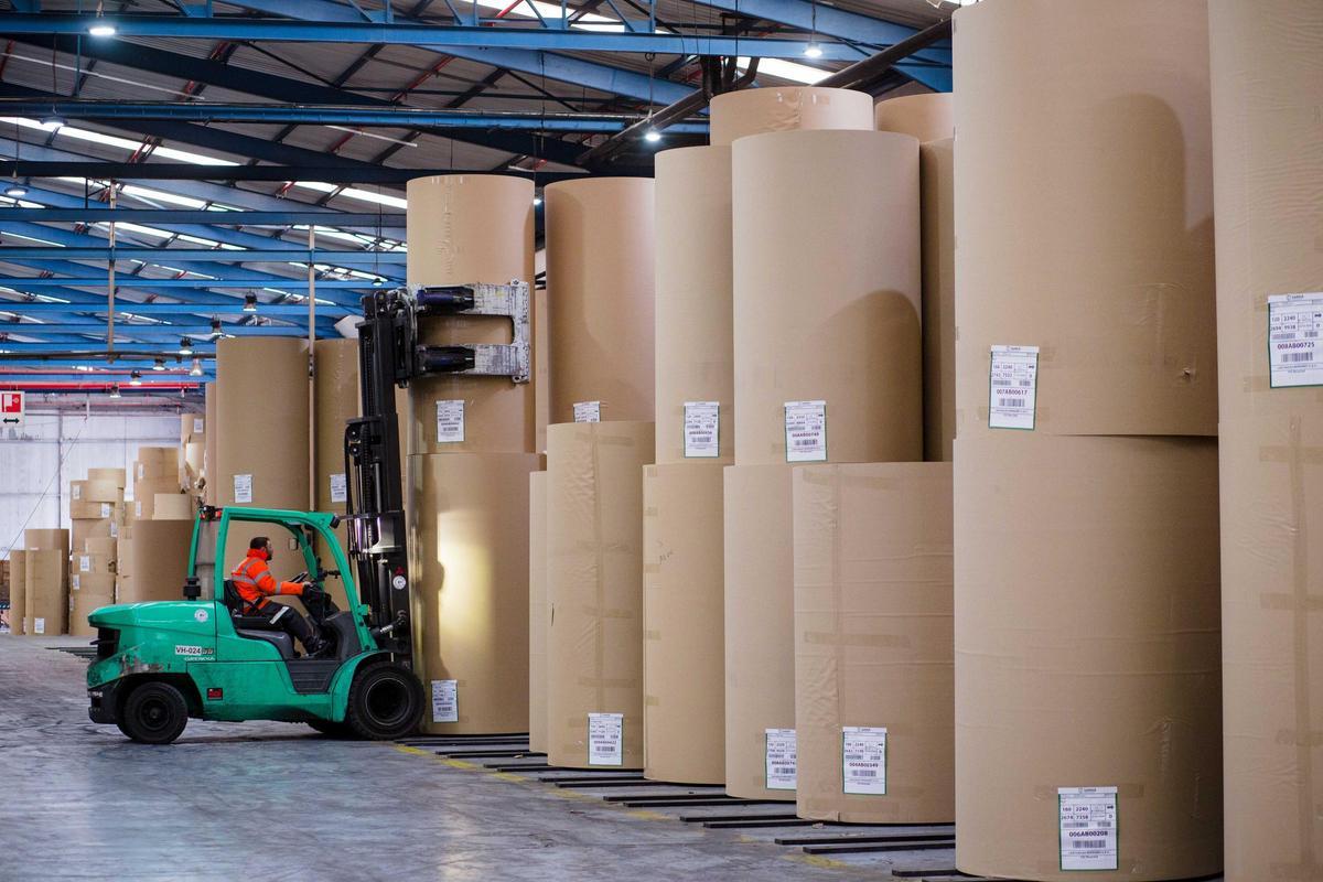 Un empleat de l’empresa carregant una bobina de paper reciclat
