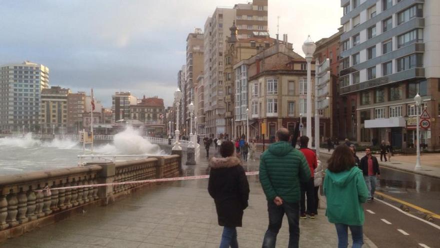 El fuerte oleaje obliga a acordonar parte del paseo del Muro en Gijón