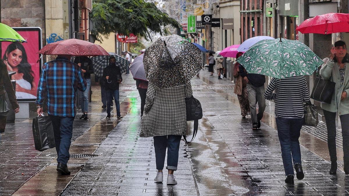 Varias personas pasean bajo la lluvia durante una borrasca anterior en Tenerife.