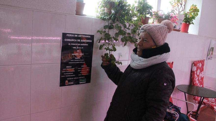 Una vecina muestra el cartel promocional del mercadillo navvideño | A. S.