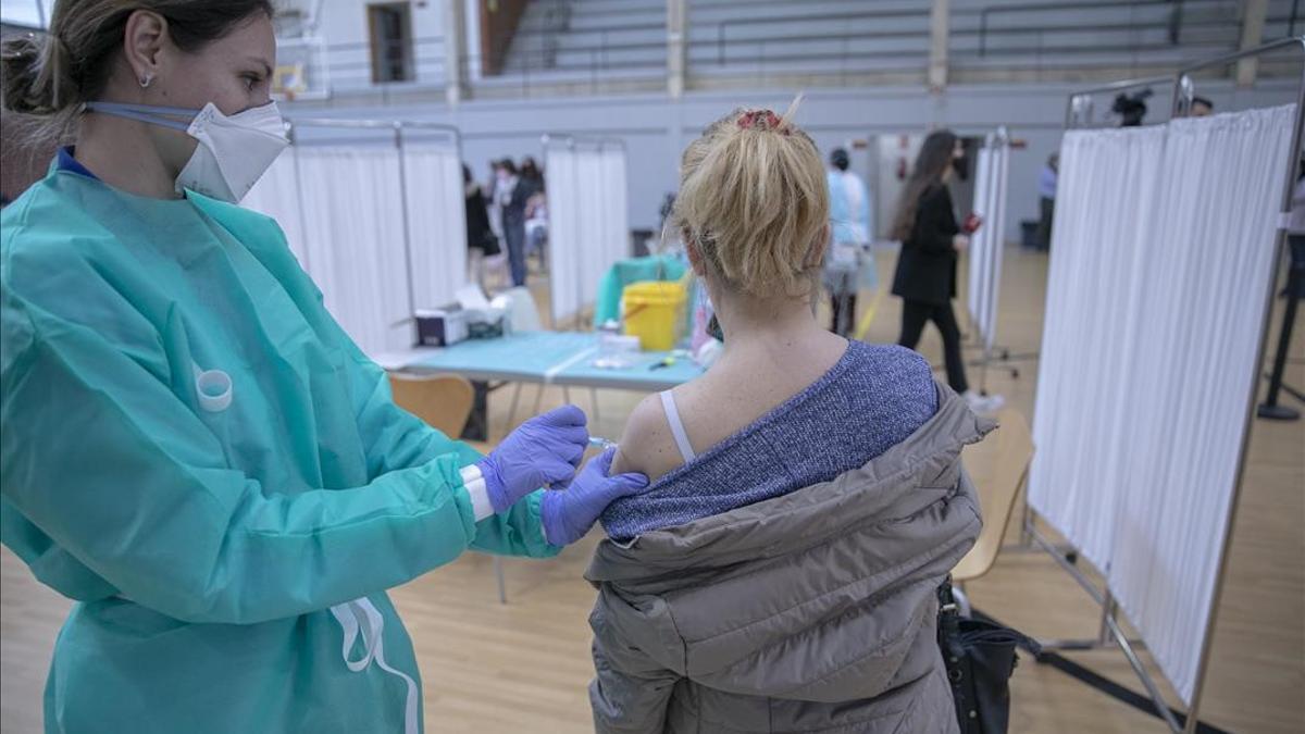 Personal sanitario durante la administracion de la primera dosis de la vacuna AstraZeneca contra la Covid-19 al personal de servicio de ayuda a domicilio en las instalaciones deportiva del pabellon Sadus de la Universidad de Sevilla  En Sevilla (Andalucia  Espana)  a 18 de febrero de 2021   18 FEBRERO 2021  Maria Jose Lopez   Europa Press  18 02 2021