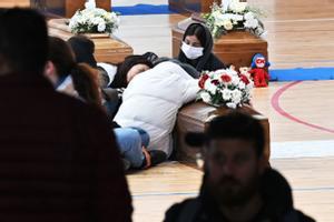 Familiares junto a los ataúdes de las 65 víctimas de un devastador naufragio de inmigrantes frente a la costa sur de Italia