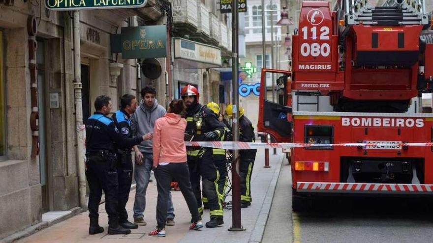 Bomberos y policías atienden al herido en el incendio ocurrido en la calle Riestra.  // Gustavo Santos