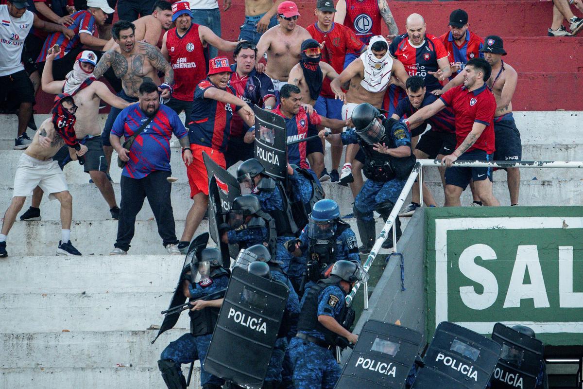 Hinchas de Cerro Porteño se enfrentan con la Policía de Paraguay durante el juego ante Olimpia, en el estadio Defensores del Chaco, en Asunción (Paraguay)