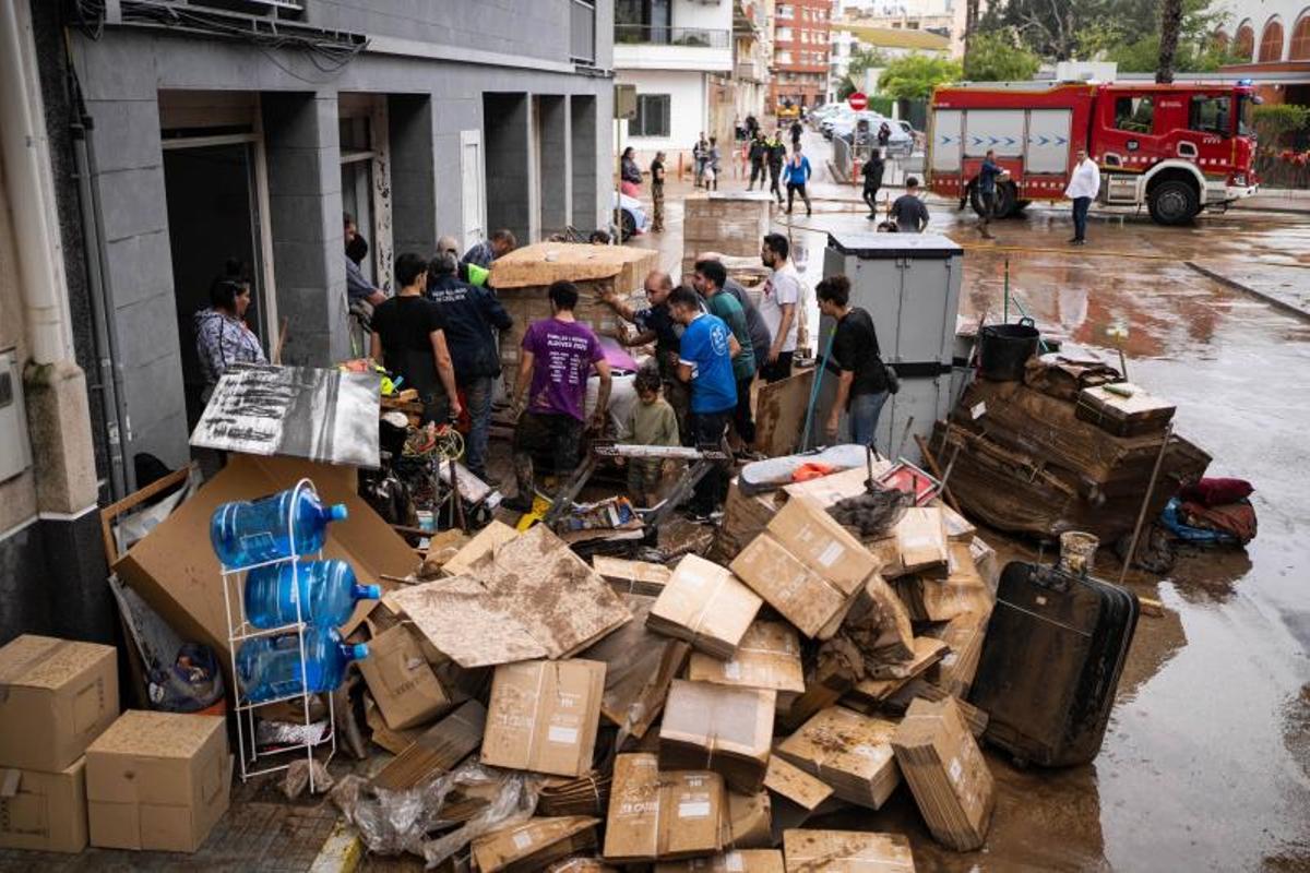 Vecinos de La Ràpita limpian calles y bajos de edificios cubiertos de lodo tras el paso de la DANA Alice, este pasado lunes.