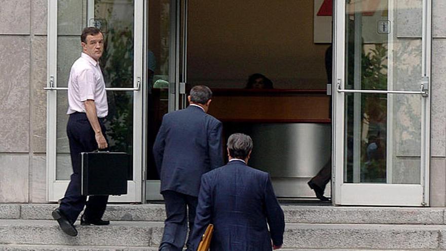 Empresa. Un trabajador acompaña a unos directivos a la entrada de un oficina.