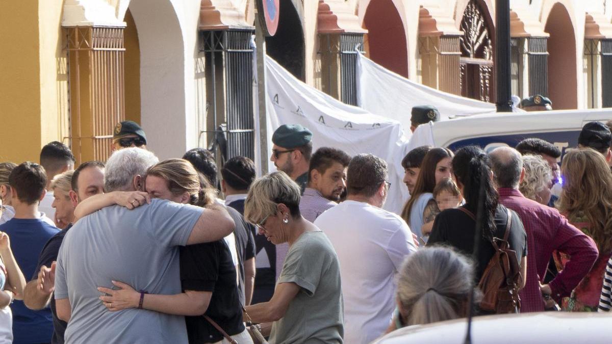 Familiares y amigos en la entrada a la vivienda donde tuvo lugar el incendio.