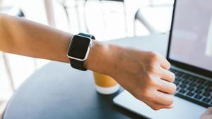 Un hombre consulta su reloj inteligente.