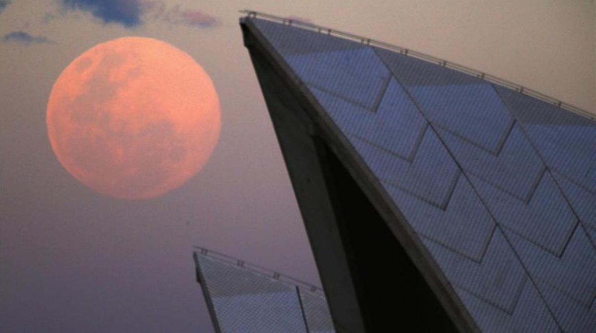 La superlluna s’eleva darrere del sostre de l’Òpera de Sydney, Austràlia.