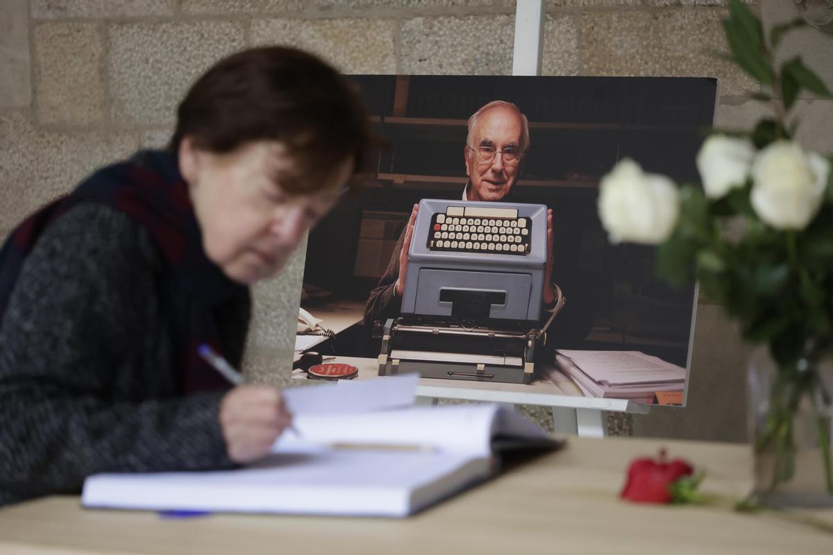 Una señora firma en el libro de condolencias.