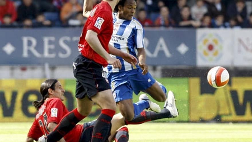 El jugador de Osasuna Astudillo trata de arrebatarle el balón desde el suelo al deportivista De Guzmán.