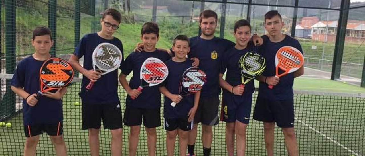 Un grupo de niños que practican pádel.