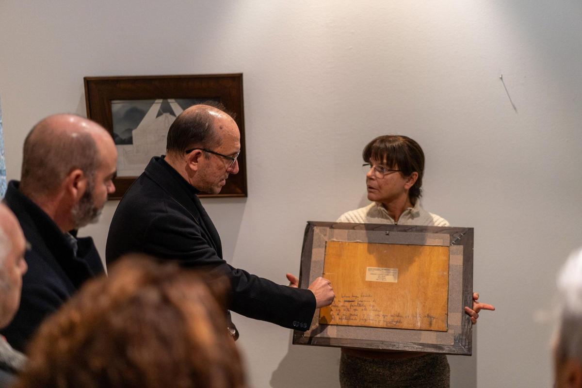 La directora del Museo Massó muestra la parte trasera del dibujo "Veleiro", con una inscripción a mano.