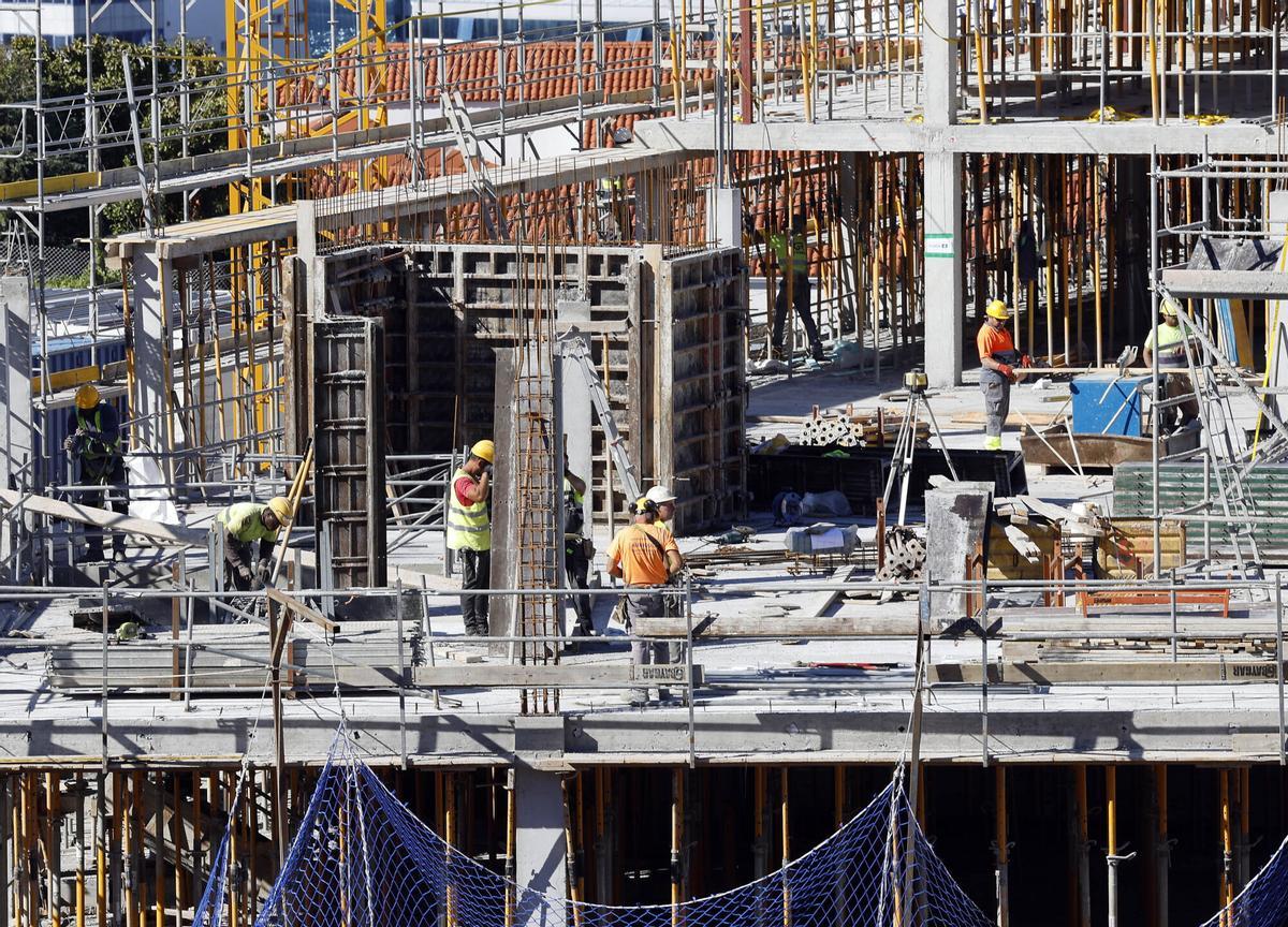 Albañiles trabajando en un edificio de viviendas en Vigo.