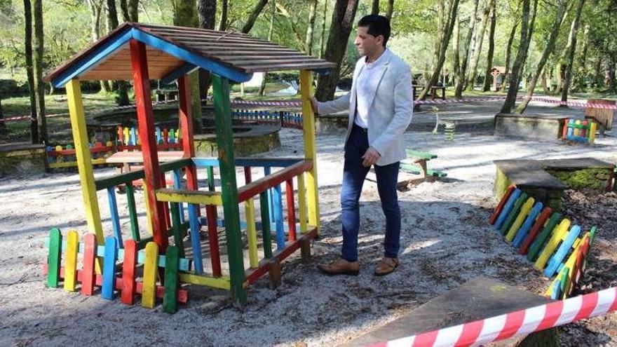 El alcalde, Andrés Díaz, observa los daños en el parque infantil. // FdV
