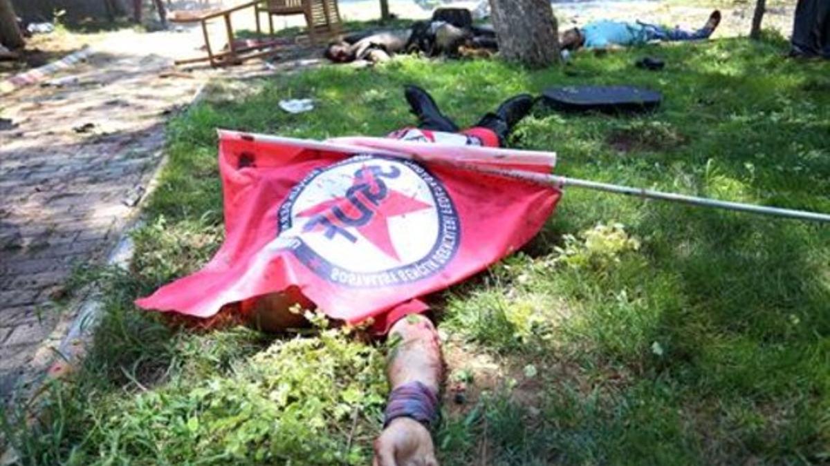 Cadáver de un joven fallecido en el atentado cubierto con una bandera de las juventudes socialistas, en Suruç.