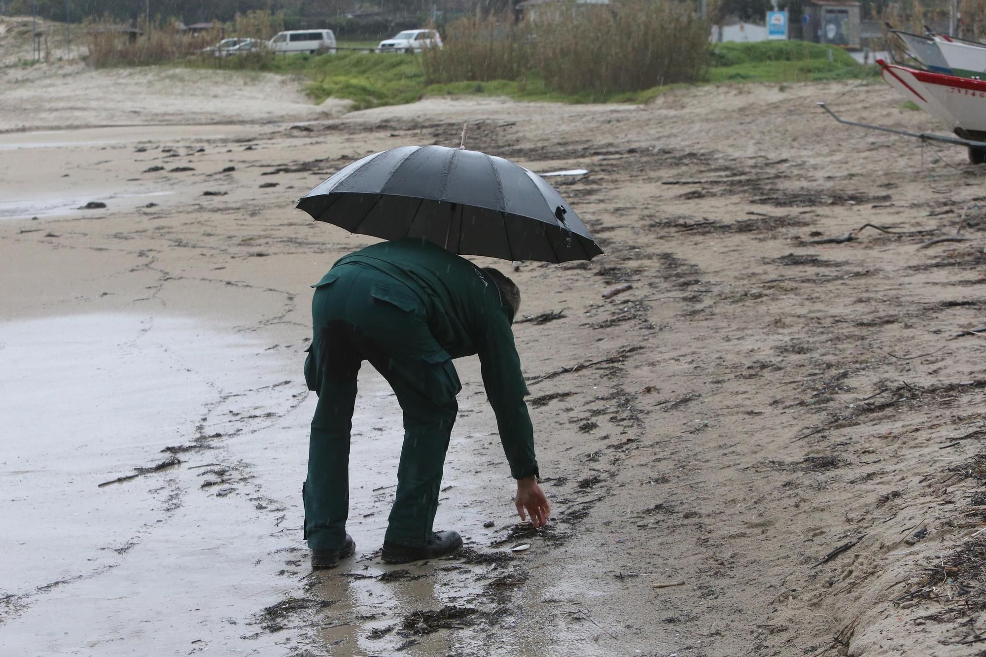 Un agente de la Xunta inspecciona la playa de Nerga, Cangas, en busca de pélets.