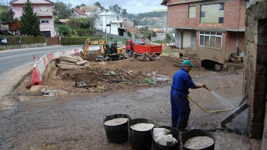 Los vecinos trabajan en la limpieza de sus propiedades con la maquinaria en las fincas, ayer en Negros. // FdV