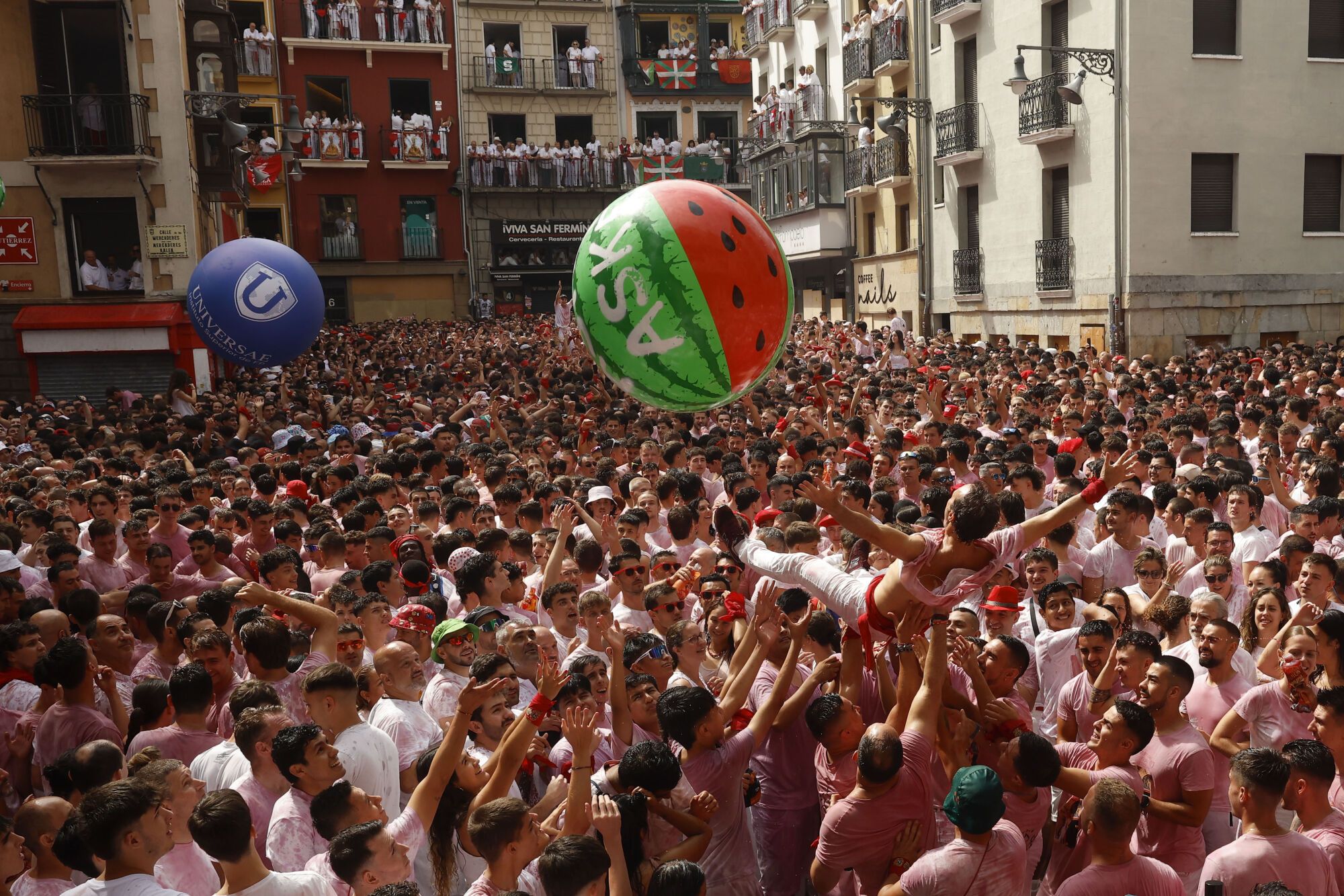 Una multitud celebra con vino el inminente comienzo de los Sanfermines, momentos antes del Chupinazo desde el balcón del ayuntamiento de Pamplona, este domingo. EFE/ Villar López