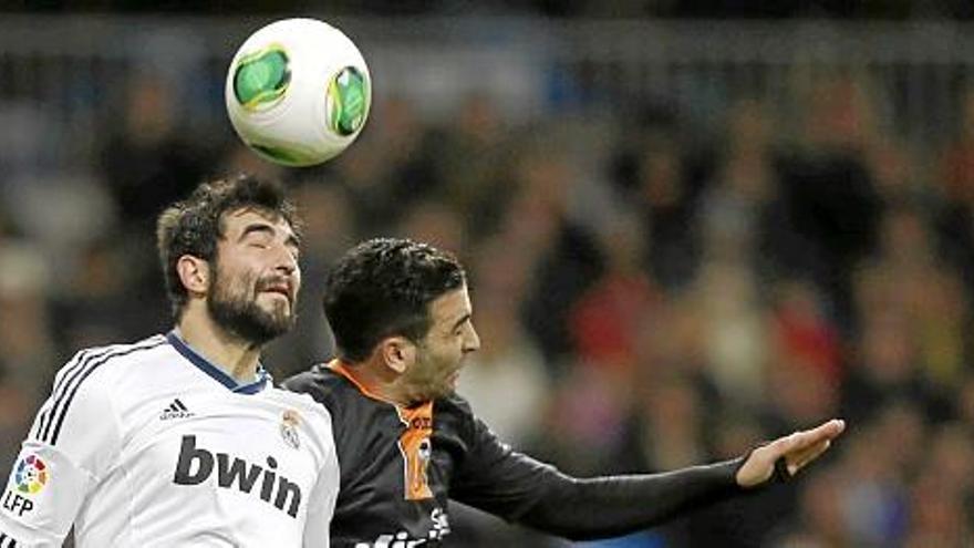 El defensa del Real Madrid, Raúl Albiol (i), salta por el balón con el francés Adil Rami, del Valencia CF, durante el partido de ida de cuartos de final de la Copa del Rey.