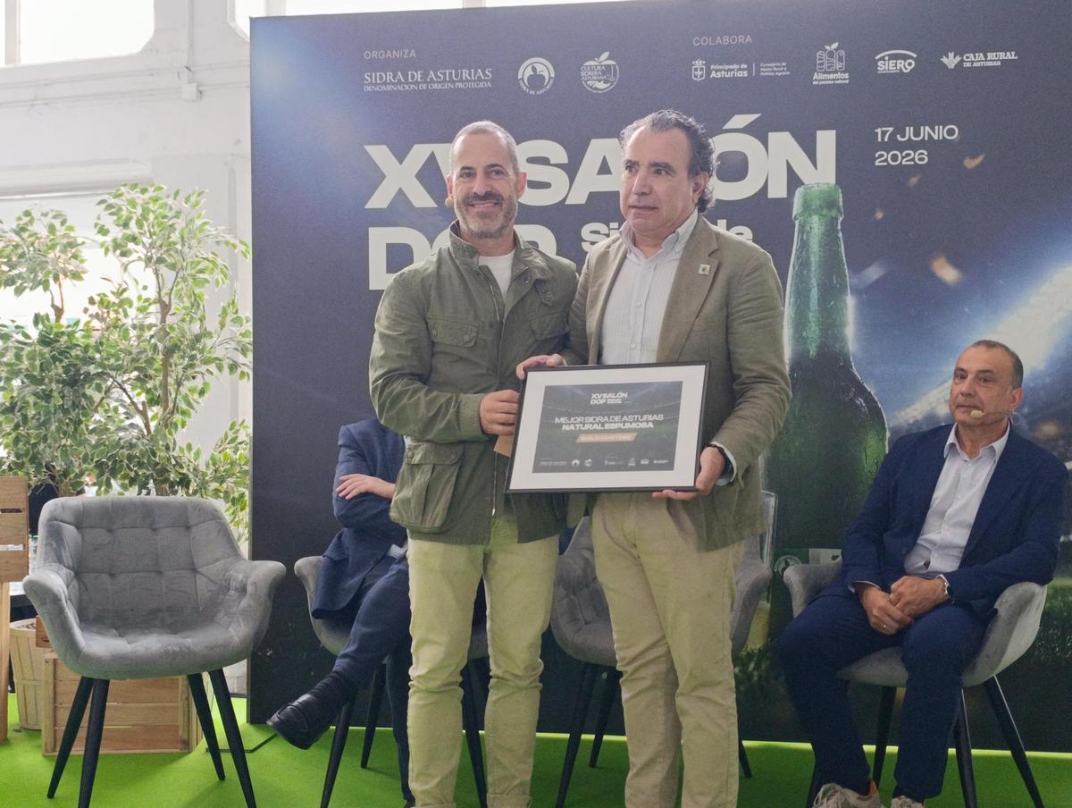 Por la izquierda, Ángel García entrega el galardón de mejor sidra espumosa a Emilio Martínez, de Sidra El Gobernador, en Villaviciosa.