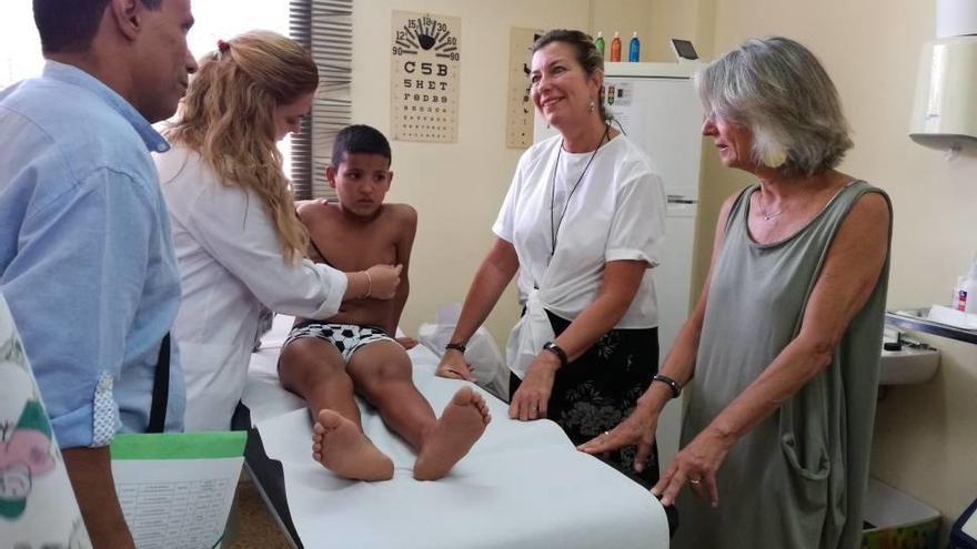 Un joven saharaui pasa la revisión junto a la presidenta de la AAPSIB i la consellera de Salud.