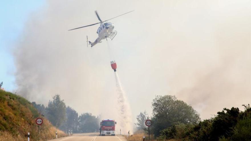 Un helicóptero trabaja ayer en el fuego de A Cañiza. |  // ANXO GUTIÉRREZ