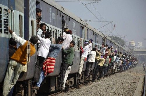 Commuters hang onto a crowded local passenger train in the eastern Indian city of Patna