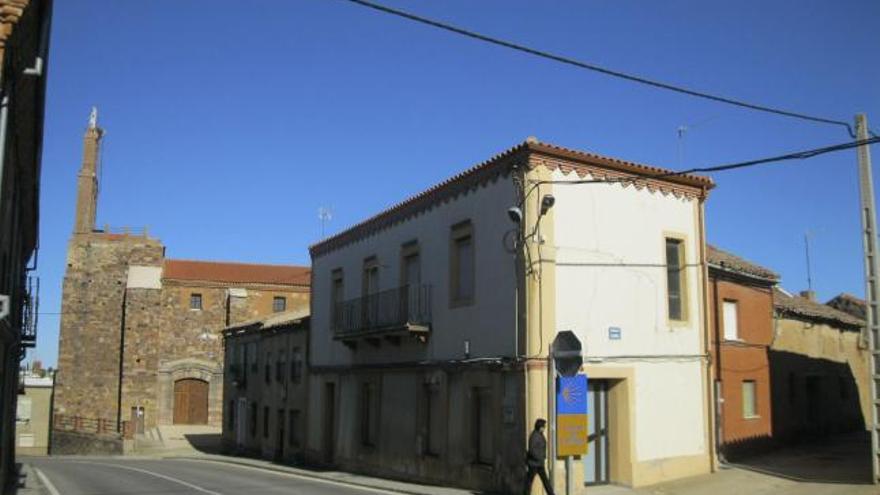 Una vecina cruza delante del edificio del antiguo Ayuntamiento de Santovenia del Esla, en la mañana de ayer.