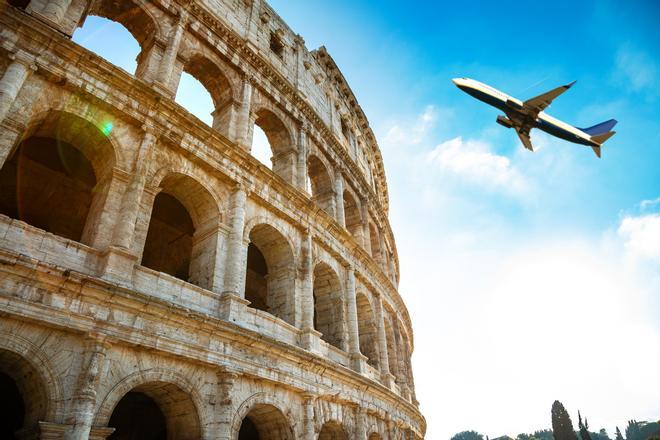 Avión sobrevolando el Coliseo, en Roma.