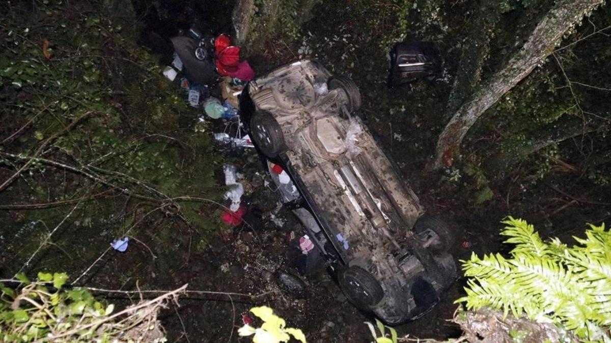 Los equipos de emergencias trabajan junto al coche accidentado en Susqueda.