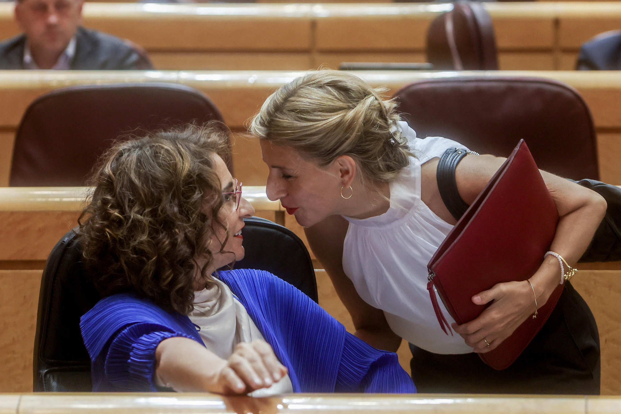 La vicepresidenta segunda del Gobierno y ministra de Trabajo, Yolanda Díaz, y la ministra de Hacienda y Función Pública, María Jesús Montero, conversan en una sesión plenaria en el Senado, a 7 de junio de 2022.