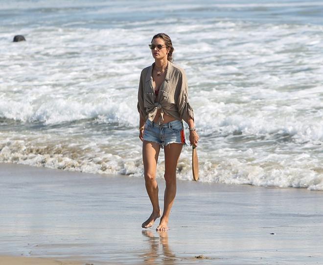 Alessandra Ambrosio con camisa de lino y shorts vaqueros en la playa