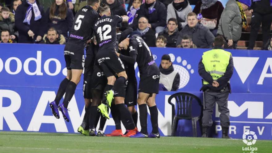 Los jugadores del Málaga rodean a Adrián para celebrar el segundo gol malaguista, ayer en La Romareda ante el Zaragoza.