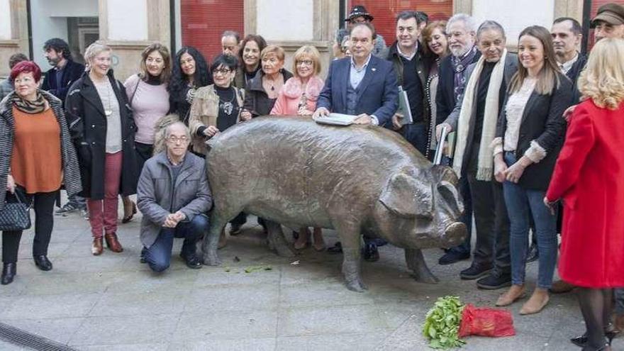 Ofrenda de un ramo de grelos, ayer, por parte de los participantes al Cocido das Artes en la estatua dedicada al cerdo. // Bernabé/Ana Agra