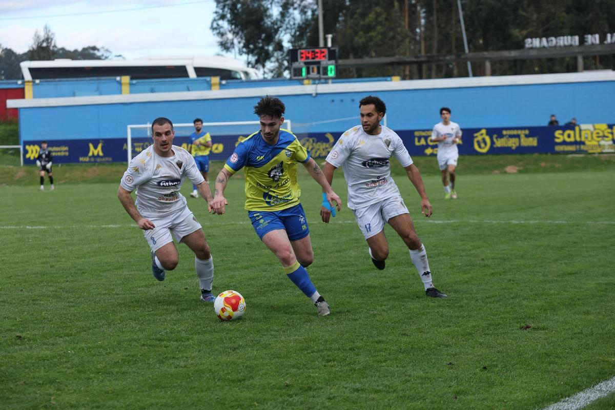 Anxo protege el balón ante el asedio de dos jugadores del Silva.