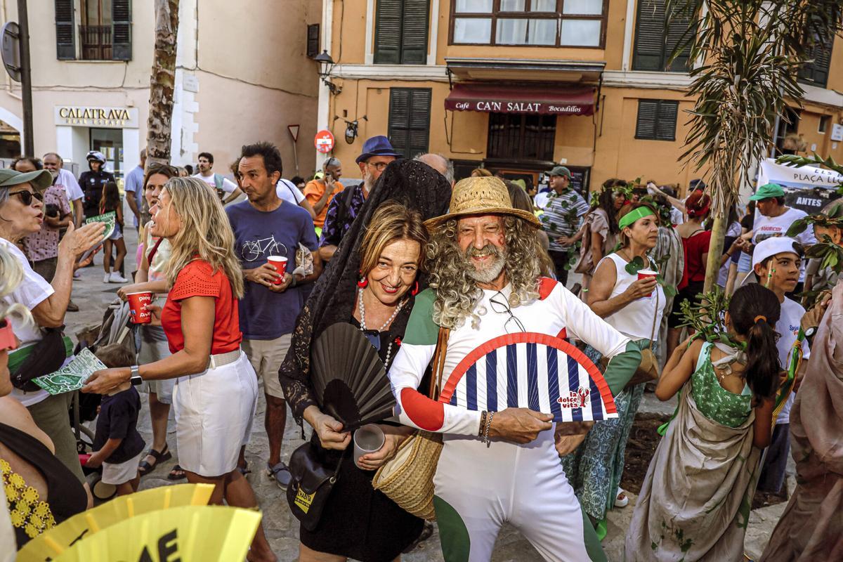 Vecinos de la Calatrava y Canamunt, muchos vestidos de verde y con ramas de árboles, se unen durante sus cercavilas para homenajear a los bellasombras talados en la plaza Llorenç Villalonga.