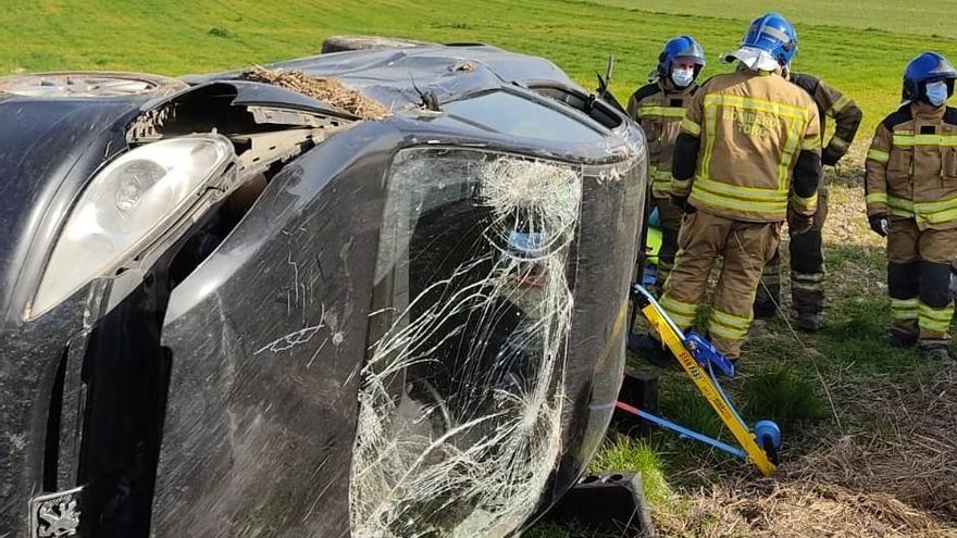 Bomberos junto al vehículo después de rescatar al conductor