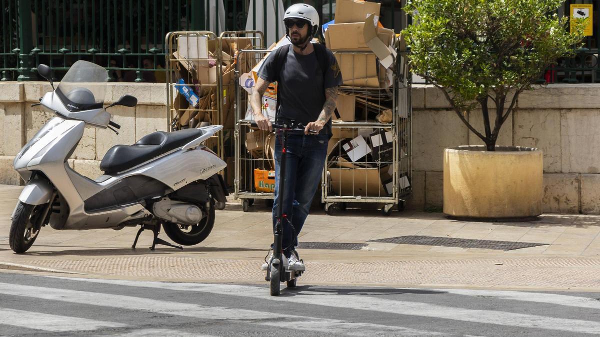 Un usuario de patinete circula sobre un paso de peatones con su VMP.