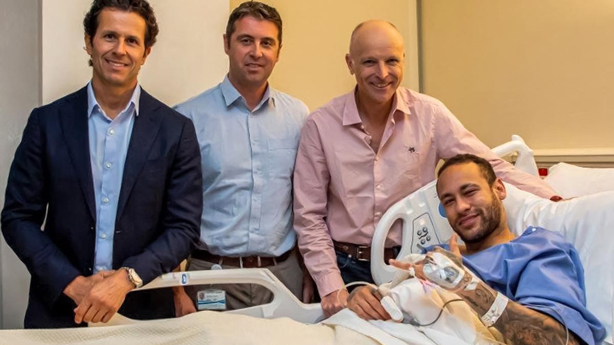 Neymar, en la cama del hospital de Doha en el que sido intervenido. Le acompañan el doctor Pieter D'Hooghe (segundo por la izquierda), el cirujano de tobillo Pierre James Calder (segundo por la derecha), y el cirujano brasileño y doctor del equipo Rodrigo Lasmar (izquierda).