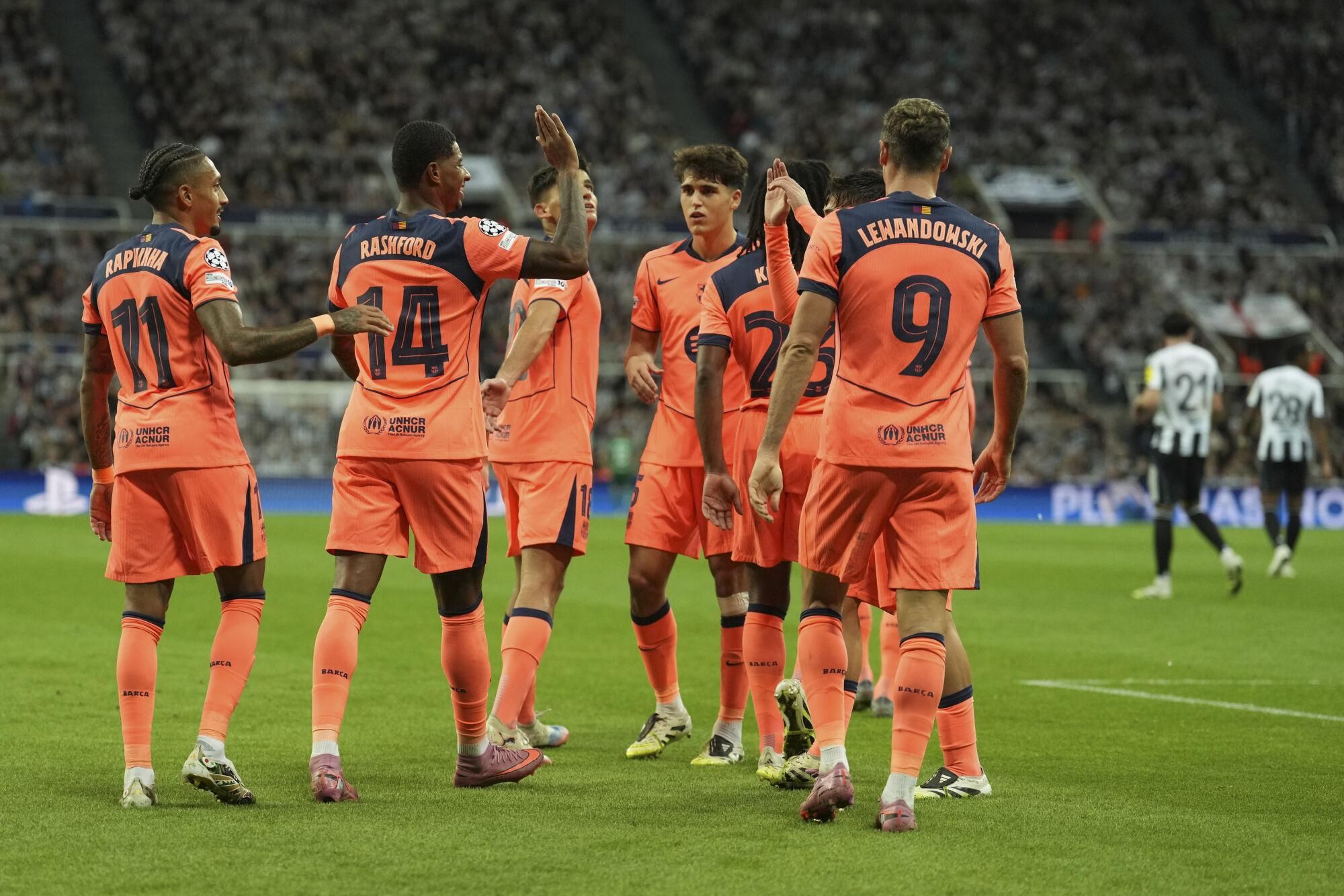 Barcelona's Marcus Rashford , second right, is congratulated by his teammates after scoring his side second goal during the Champions League, opening phase soccer match between Newcastle and Barcelona in Newcastle, England, Thursday, Sept. 18, 2025. (AP Photo/Jon Super)
