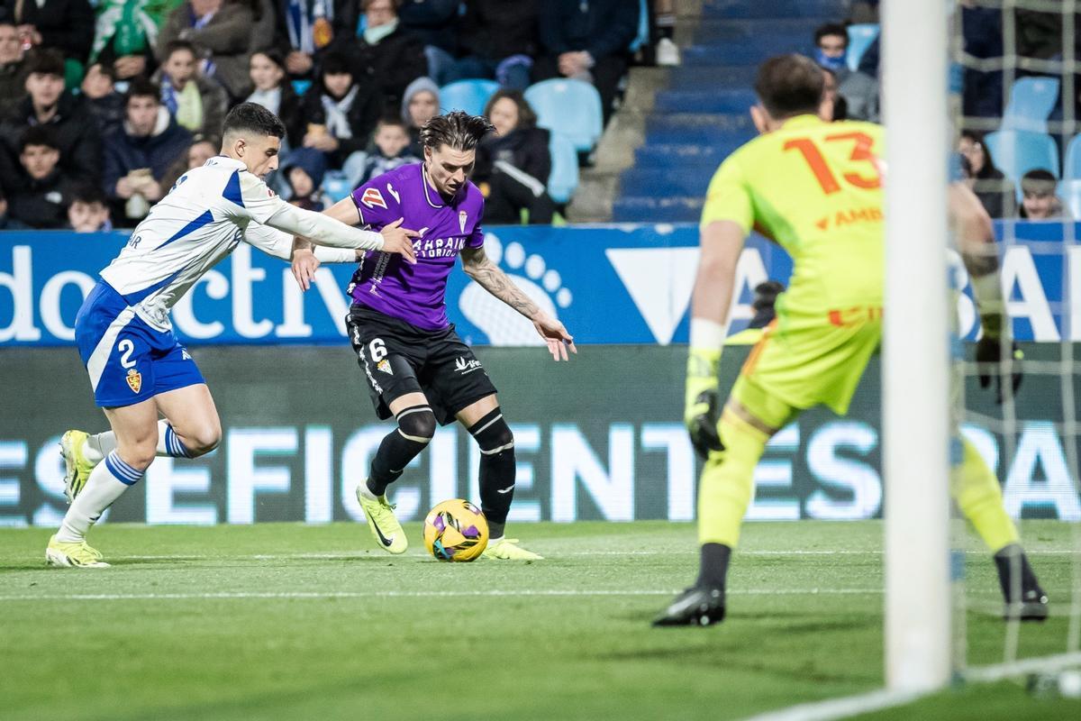 Álex Sala protege el balón ante Marcos Luna, en La Romareda.