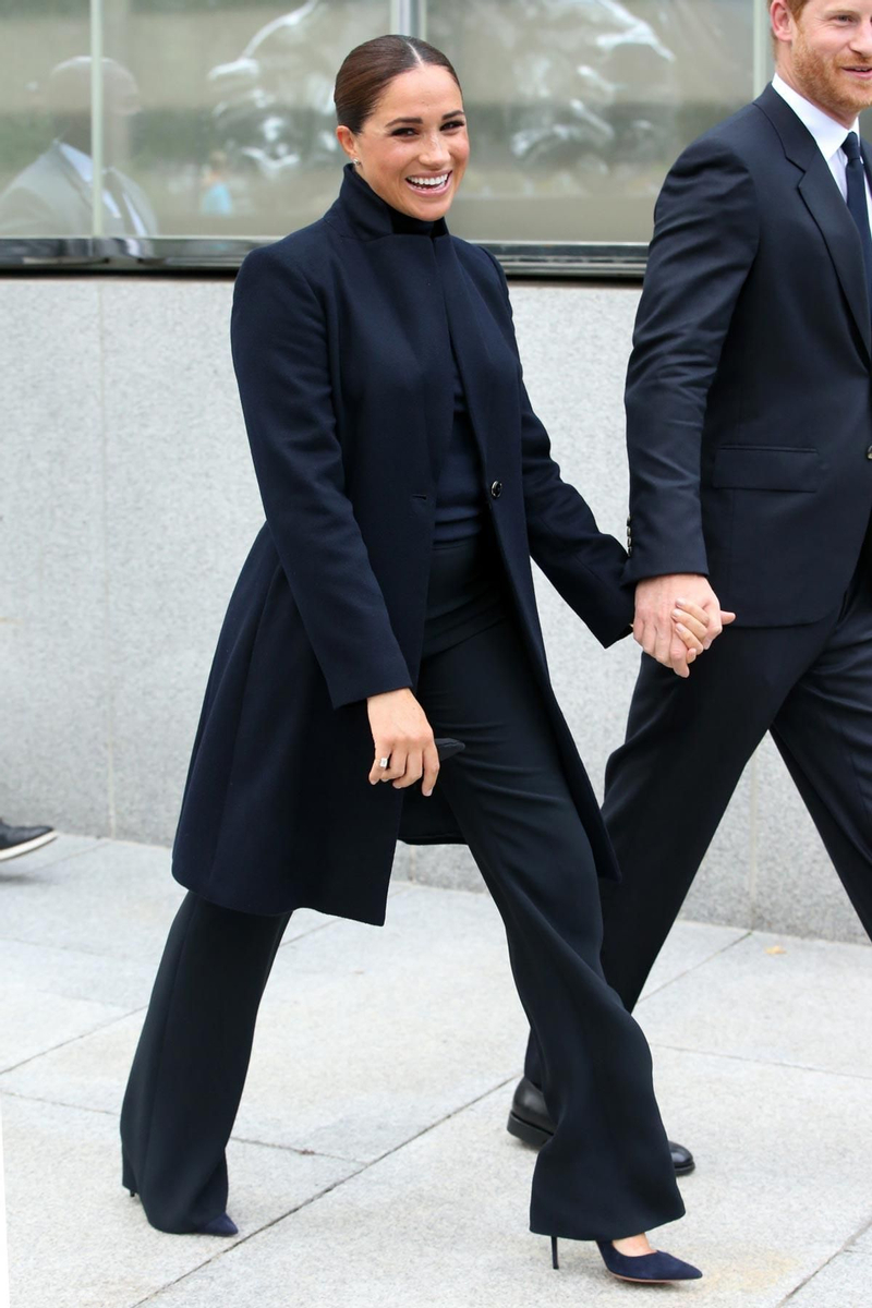 Meghan Markle, con abrigo, pantalones acampanados y jersey de cuello alto azul oscuro casi negro